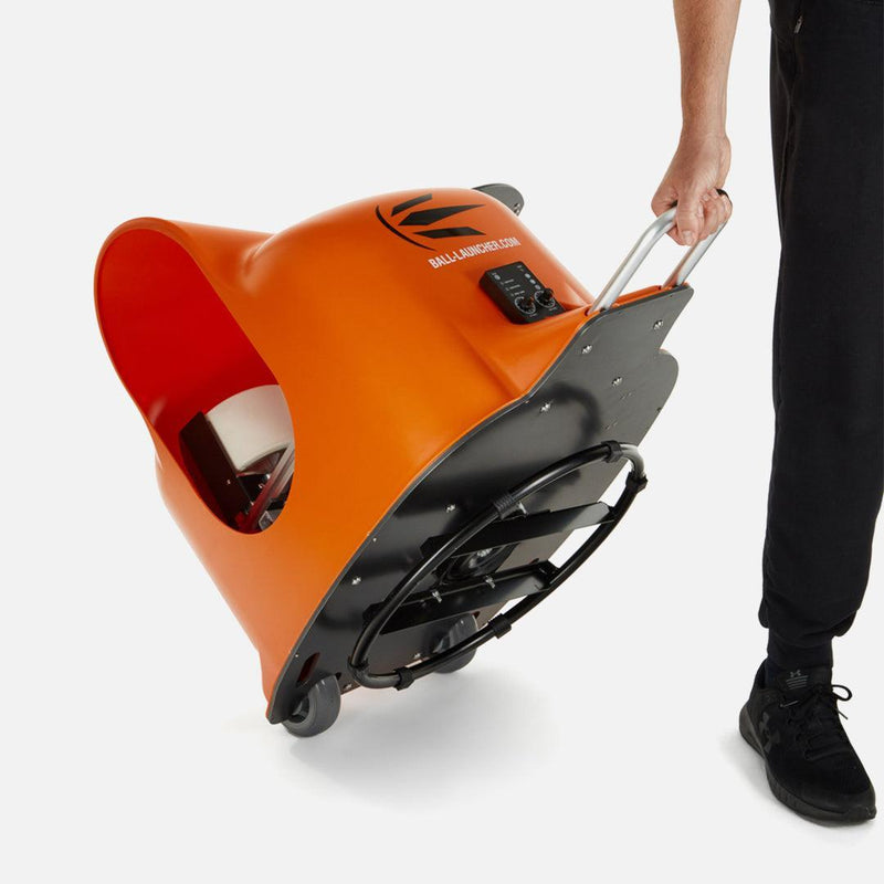 The portable ball launcher being rolled on on its wheels